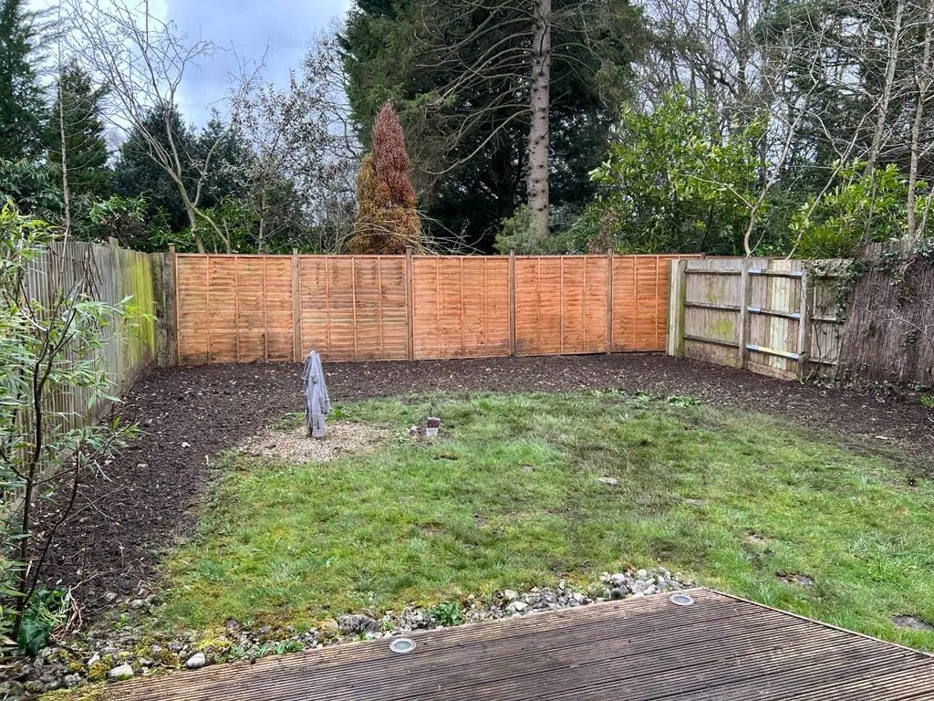 there is a wooden fence in the backyard with a wooden deck