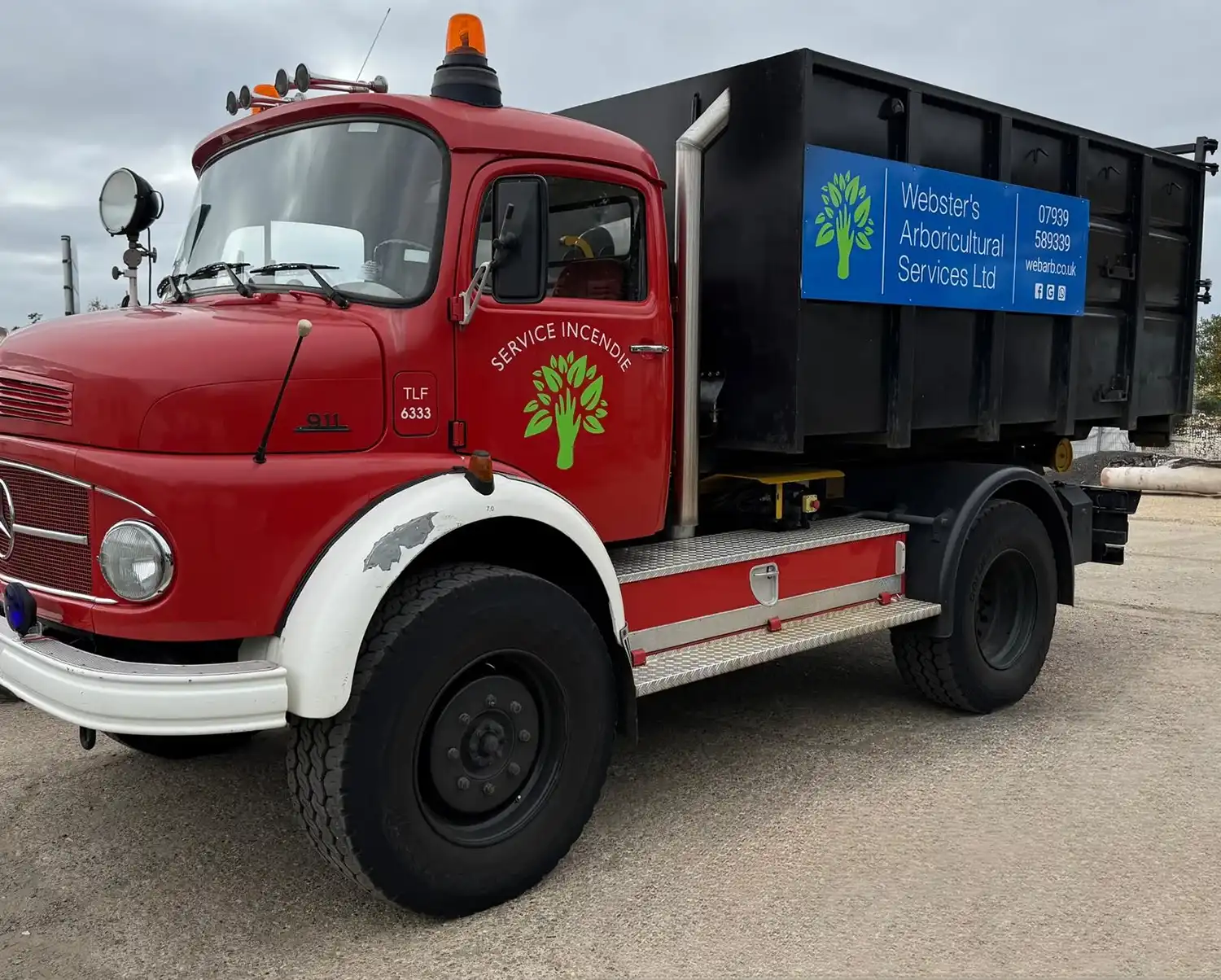 Red and white truck with black cargo bed and Webster's Arboricultural Services Ltd sign on the side.